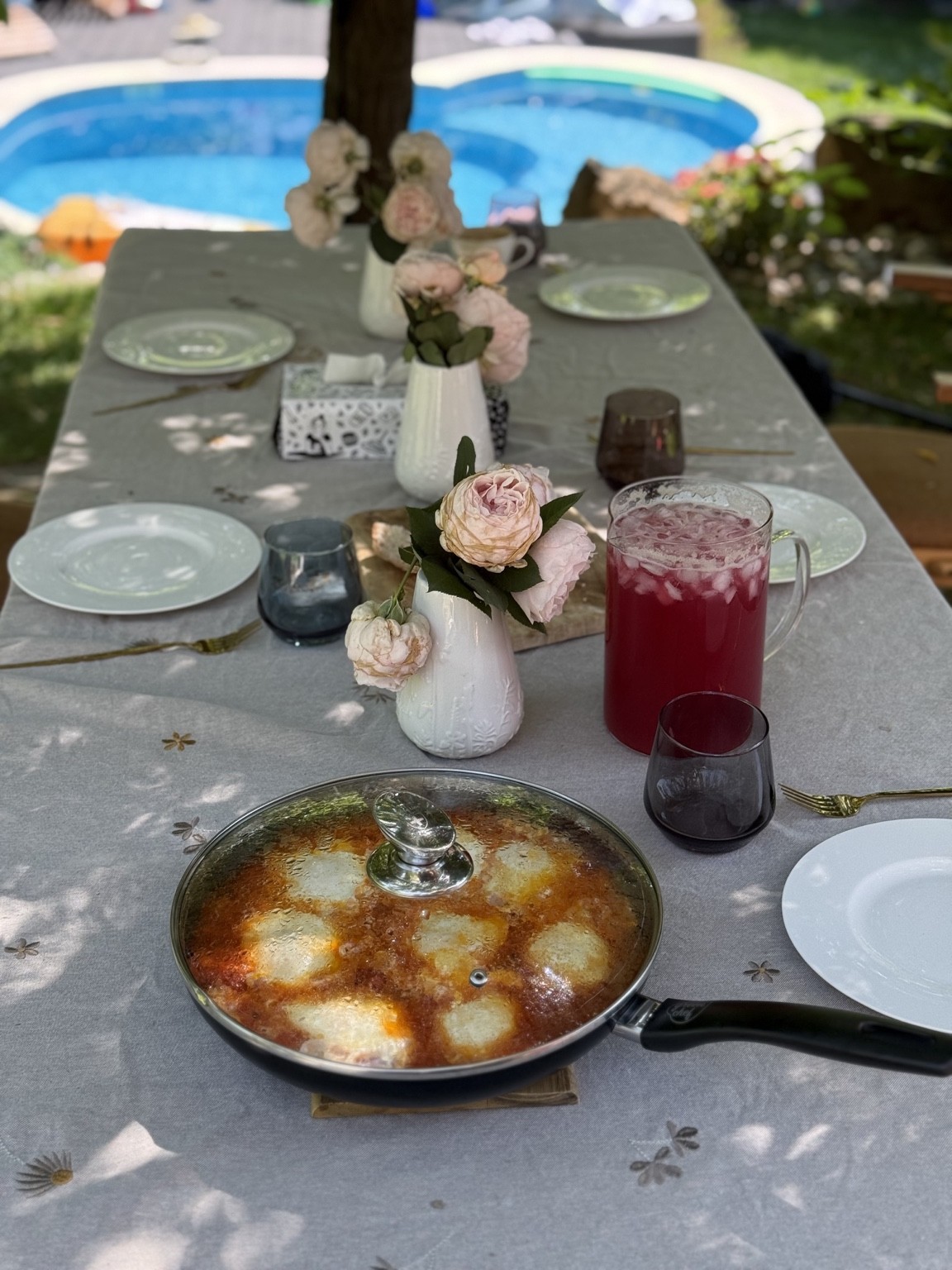 Tigaie cu shakshuka pe masa de mic dejun din grădină